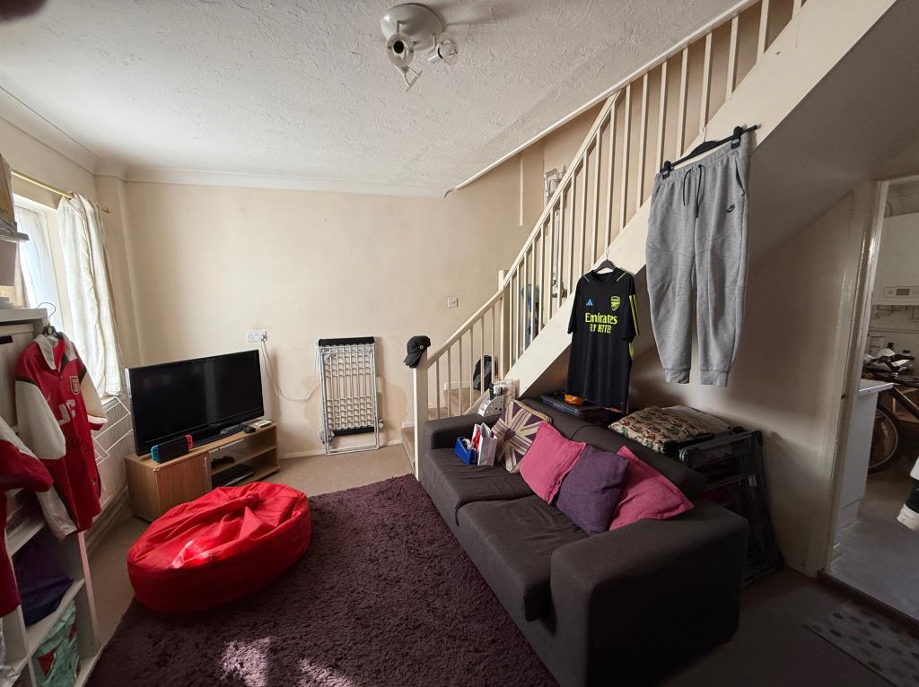 Lot: 31 - TERRACE HOUSE FOR IMPROVEMENT IN COLCHESTER CITY CENTRE - View of living room with stair to first floor and access to kitchen